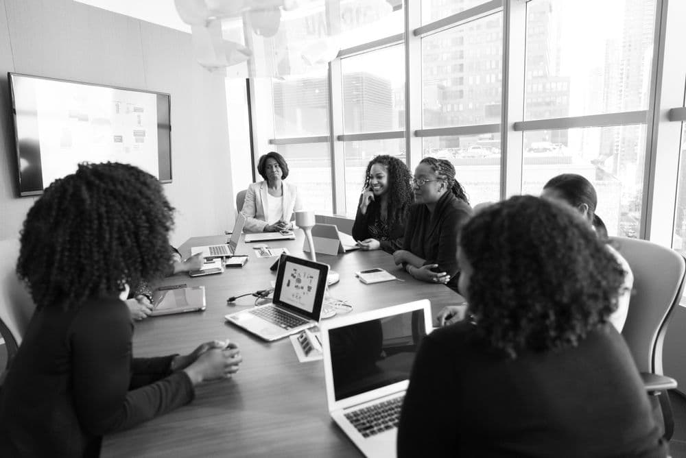 A team collaborating around a table with their laptops